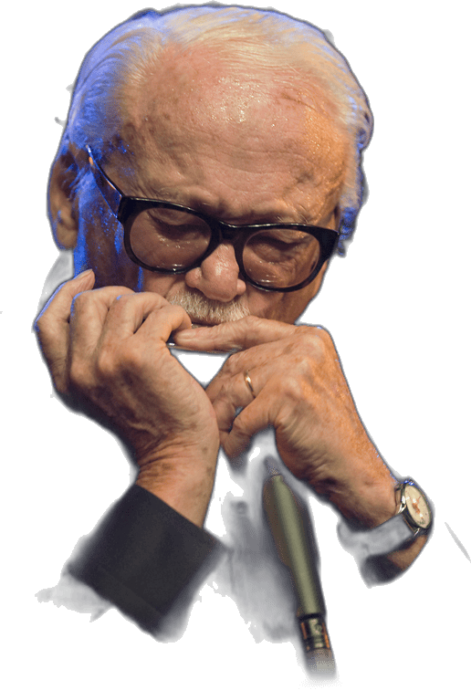 Toots Thielemans souriant, harmonica chromatique aux lèvres, sous une lumière de scène bleutée